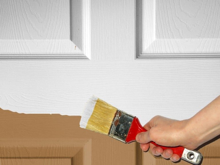 Pintando puerta de madera con brocha