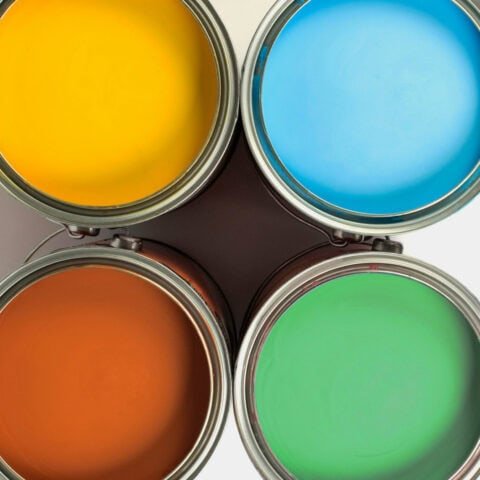 Cuatro latas de pintura de colores cálidos y fríos