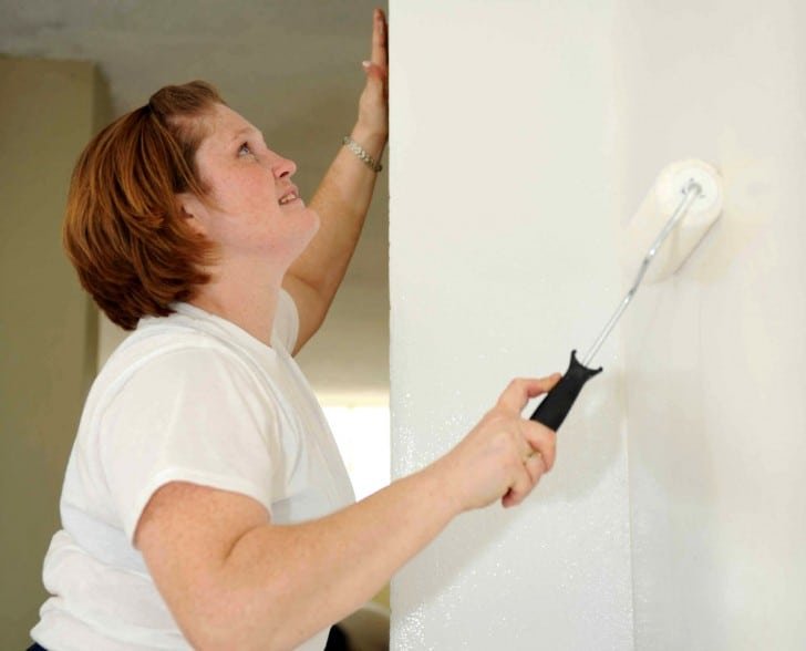 Mujer pintando la pared