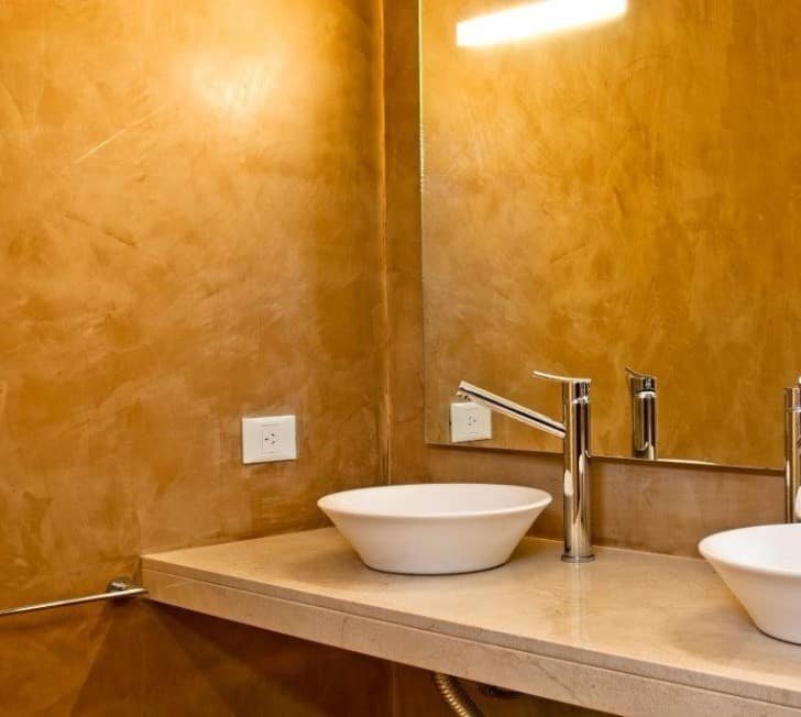 Estuco decorativo color ocre en las paredes de un baño moderno y minimalista