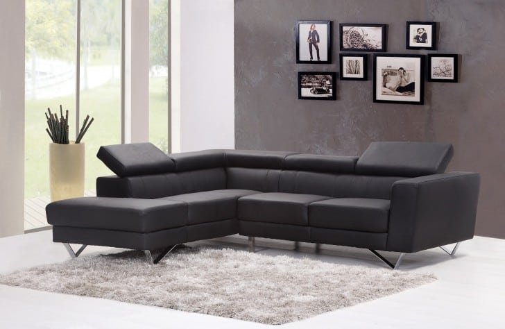 Pared gris y sofá de cuero negro