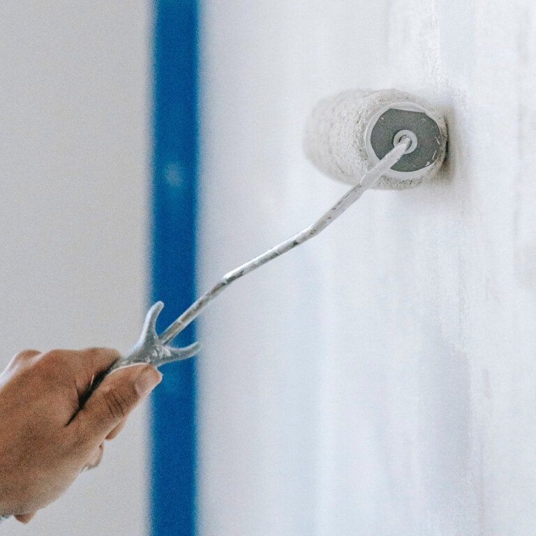 Aplicación de imprimación selladora con rodillo antes de pintar la pared