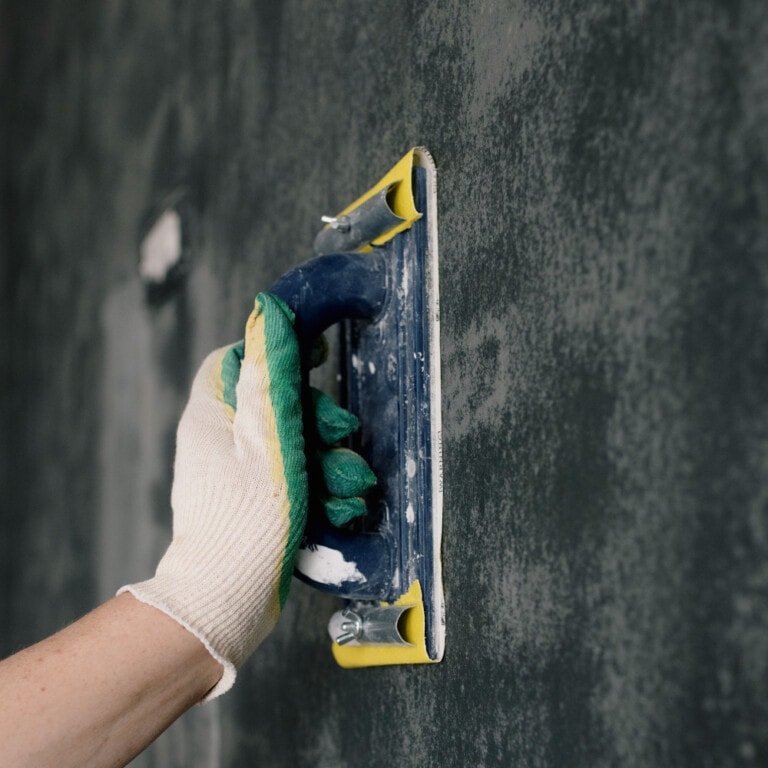 Lijado de la pared con un fratacho o taco para lijar pared