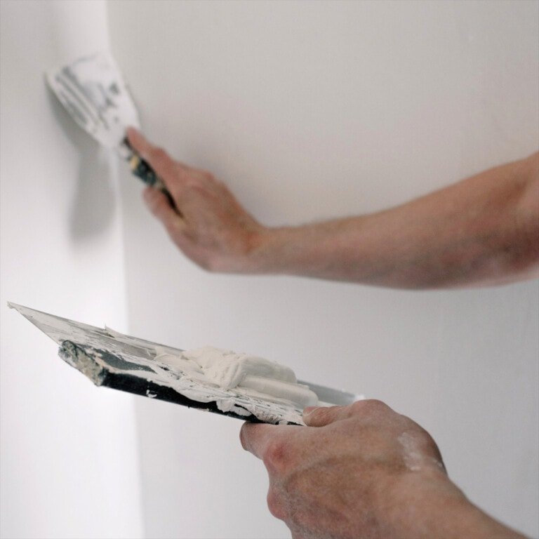 Aplicando masilla para preparar la pared antes de pintar
