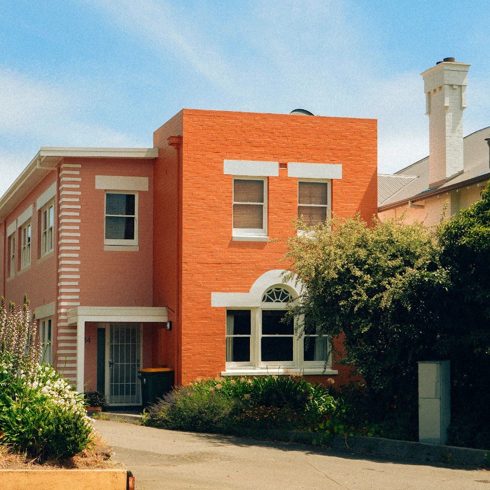 Fachada de casa en dos tonos de naranja y combinada con blanco