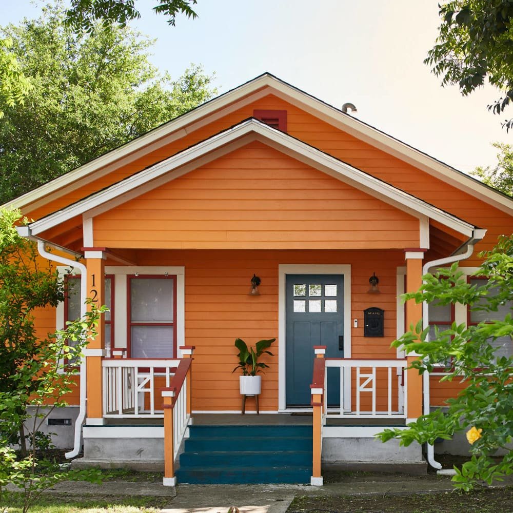 Bungalow o casa estilo americano de color naranja intenso y blanco
