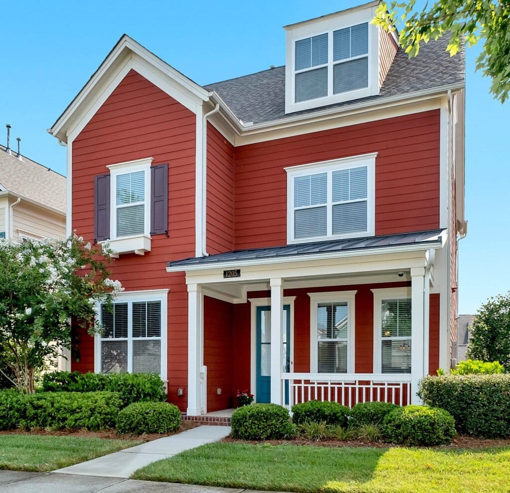 Exterior de casa estilo americano de dos plantas en color rojo y blanco