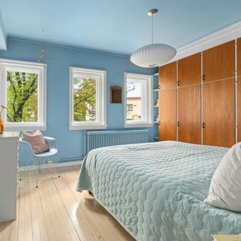 Recámara de color azul celeste con muebles en madera y blanco