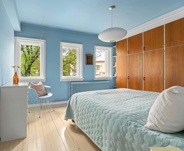 Recámara de color azul celeste con muebles en madera y blanco